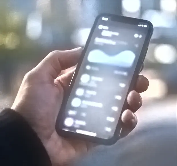 A hand holding a phone showing an app interface