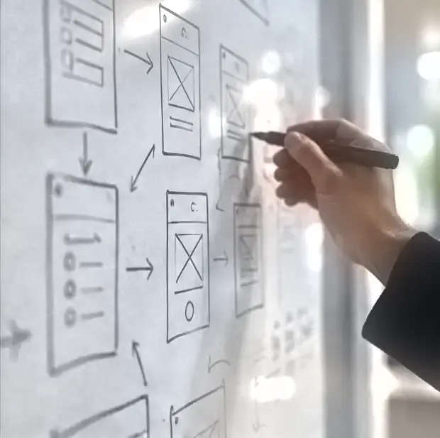 A hand sketching app wireframes on a whiteboard